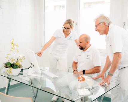 Ärzteteam bespricht sich am Computer